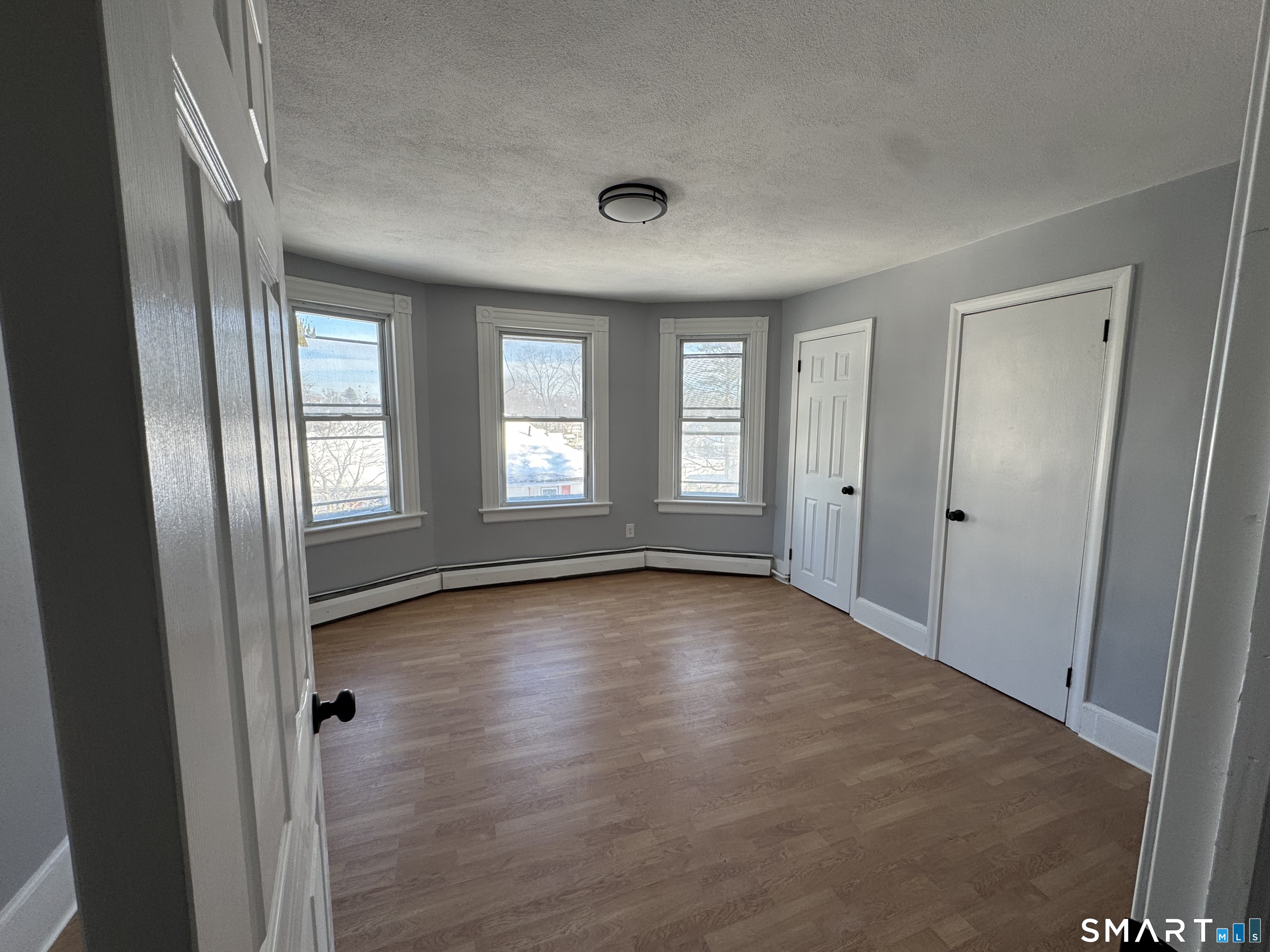 299 Linnmoore Street Hartford, CT 06106 - Photo 22 of 23 an empty room with wooden floor and windows