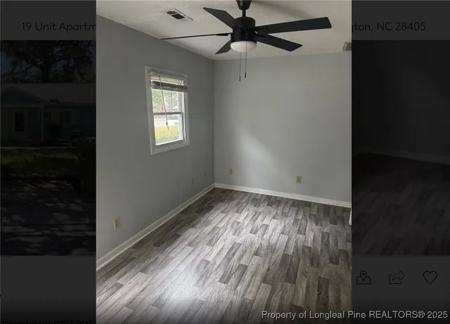 a view of empty room with wooden floor