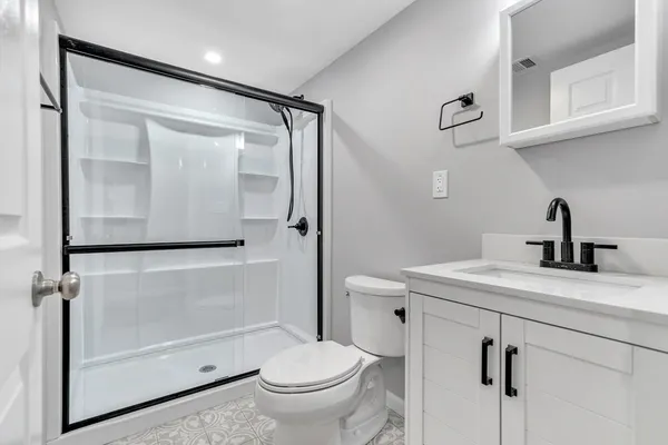 a bathroom with a sink a toilet and shower
