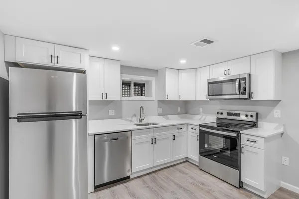 a kitchen with a refrigerator a sink and dishwasher a refrigerator with wooden floor