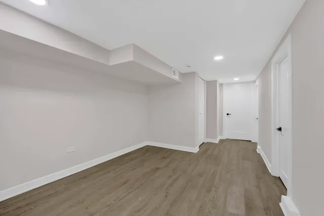 a view of a big room with wooden floor and windows