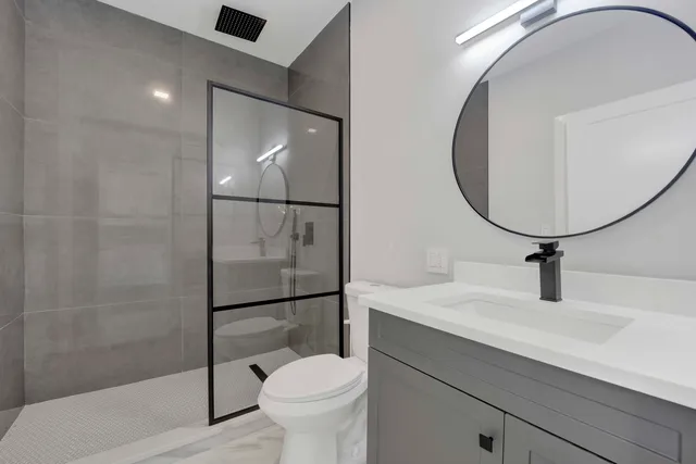 a bathroom with a sink a toilet and shower