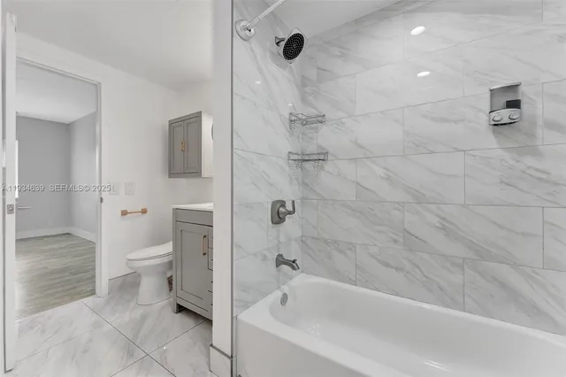a bathroom with a granite countertop toilet a sink and shower