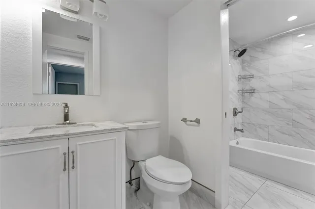 a bathroom with a granite countertop toilet a sink and bathtub