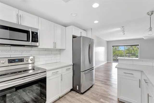 a kitchen with stainless steel appliances a refrigerator sink and microwave