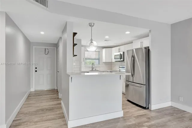 a kitchen with stainless steel appliances a refrigerator and a stove top oven