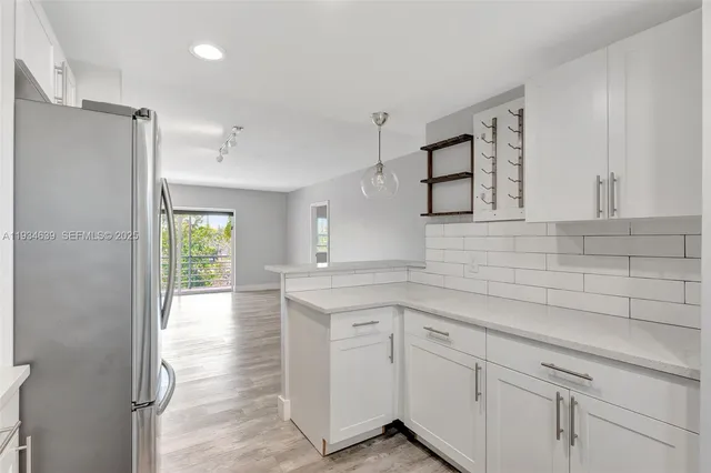 a kitchen with white cabinets and window