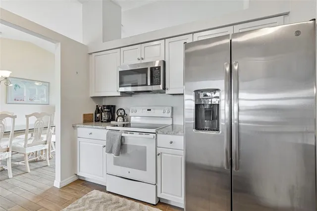 a kitchen with white cabinets and stainless steel appliances