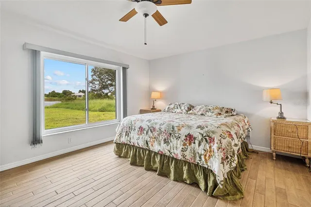 a bedroom with a bed wooden floor and window