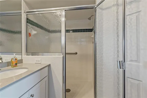 a bathroom with a shower sink vanity and mirror