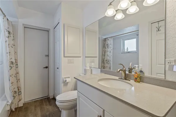 a bathroom with a granite countertop sink a toilet and a mirror