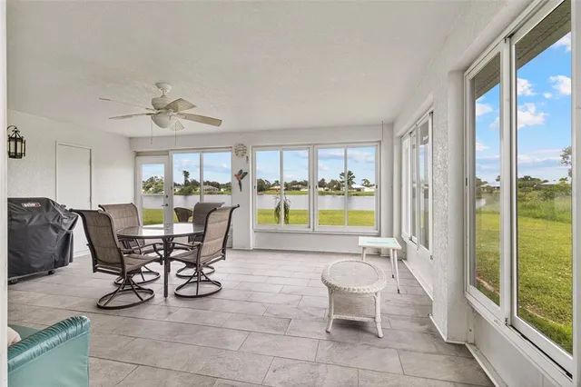 a living room with furniture and floor to ceiling windows