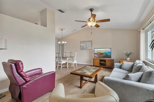 a living room with furniture a ceiling fan and a window