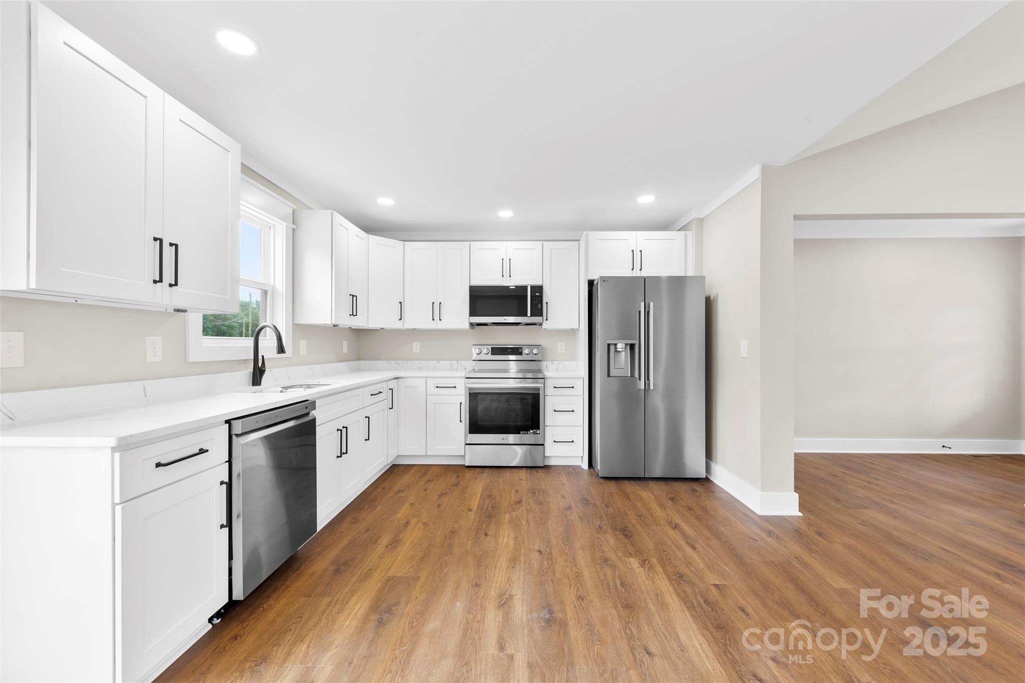 6788 Clyde Wehunt Road Cherryville, NC 28021 - Photo 7 of 25 a kitchen with wooden floors stainless steel appliances and window