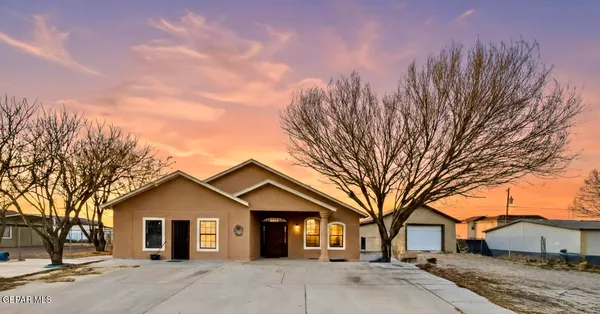 a view of a white house with a large tree and a yard