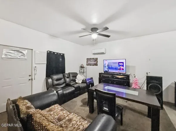 a living room with lots of furniture and a view of kitchen