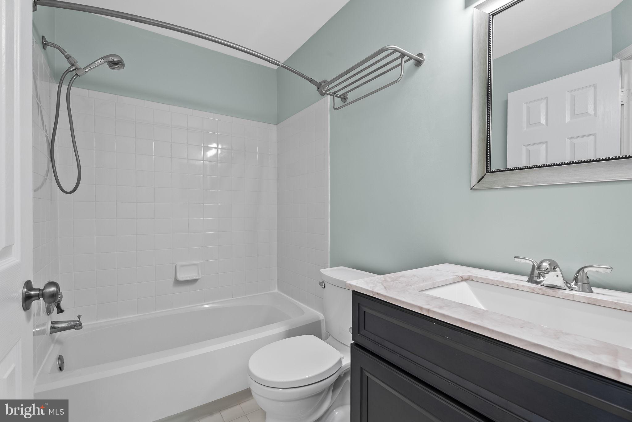 6267 Taliaferro Way Alexandria, VA 22315 - Photo 28 of 49 a bathroom with a granite countertop sink a toilet and shower