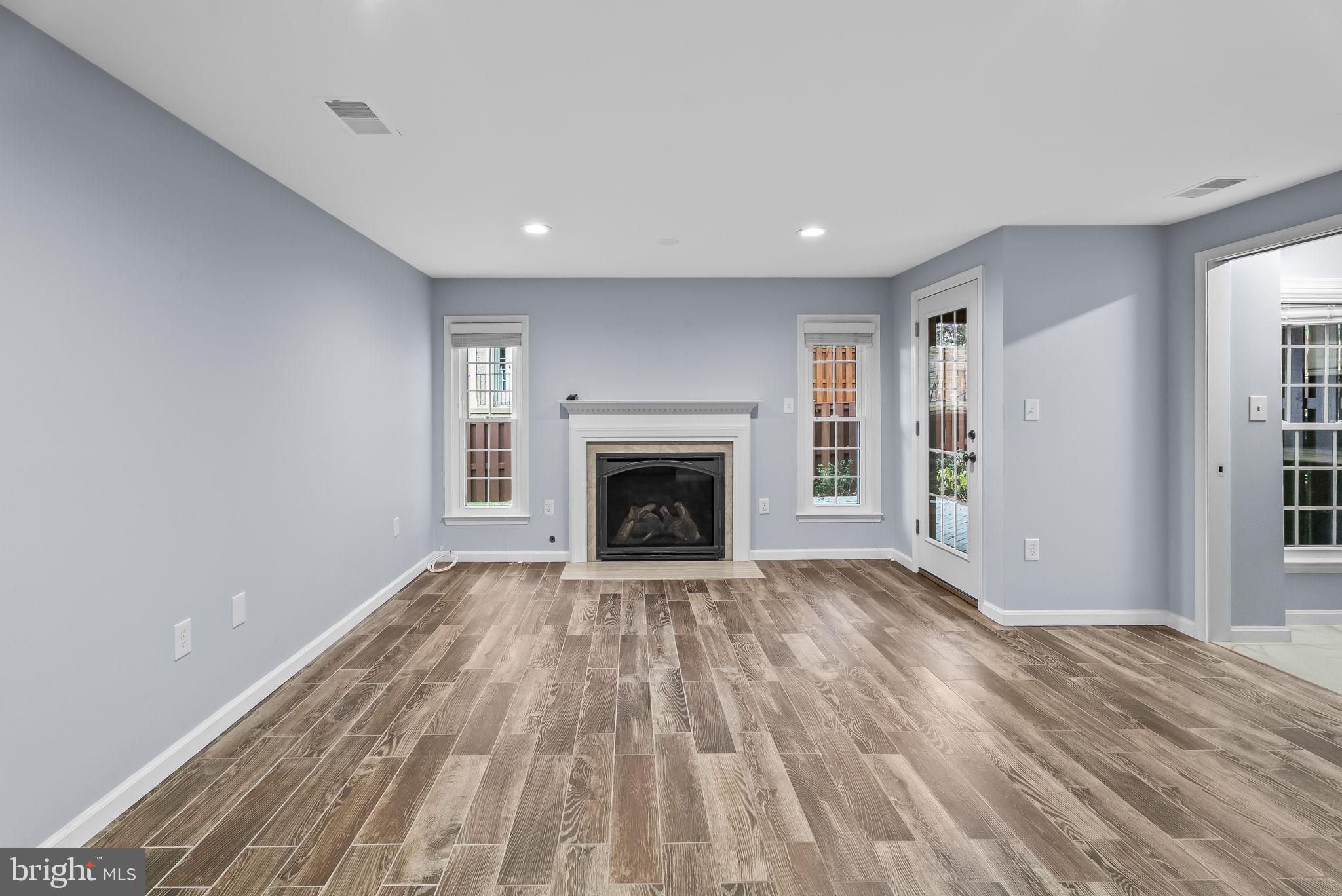 6267 Taliaferro Way Alexandria, VA 22315 - Photo 29 of 49 a view of an empty room with wooden floor fireplace and a window