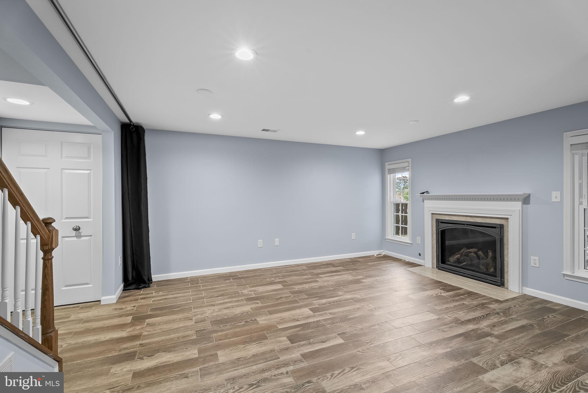 6267 Taliaferro Way Alexandria, VA 22315 - Photo 32 of 49 an empty room with wooden floor a fireplace and a window