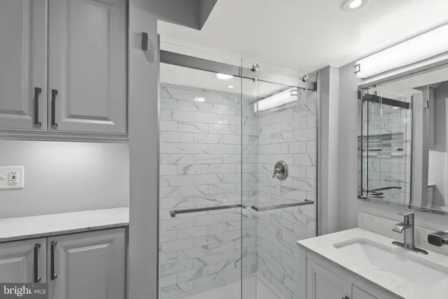 a bathroom with a shower sink and mirror