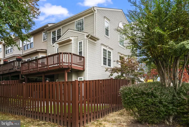 a view of a house with a small yard and wooden fence