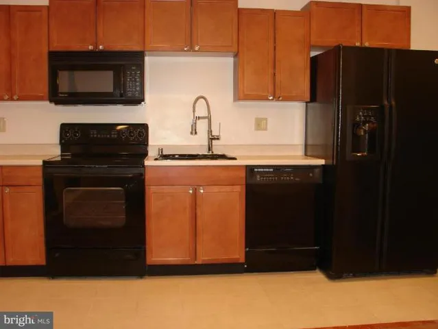 a kitchen with granite countertop a refrigerator stove and microwave