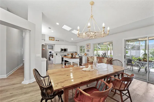 a dining room with furniture a chandelier and wooden floor