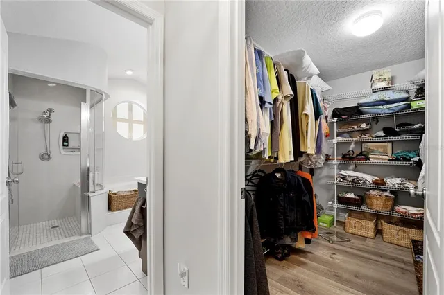 a view of walk in closet with clothes and shoes