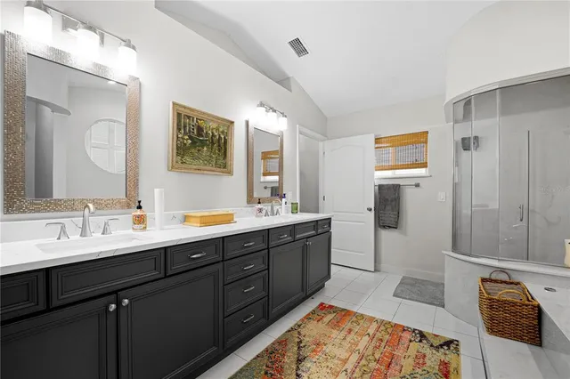 a spacious bathroom with a double vanity sink a mirror and a shower