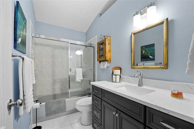 a bathroom with a sink a toilet a mirror and shower