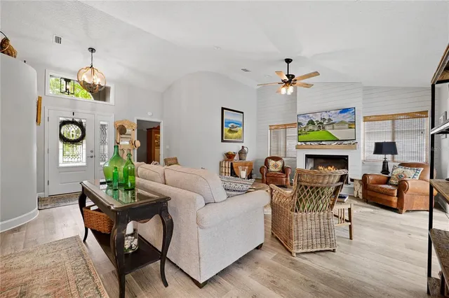 a living room with furniture a fireplace and a chandelier