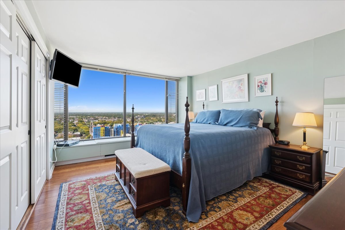 5455 North Sheridan Road, Unit 26122615 Chicago, IL 60640 - Photo 7 of 27 a living room with a bed furniture flat screen tv and a large window