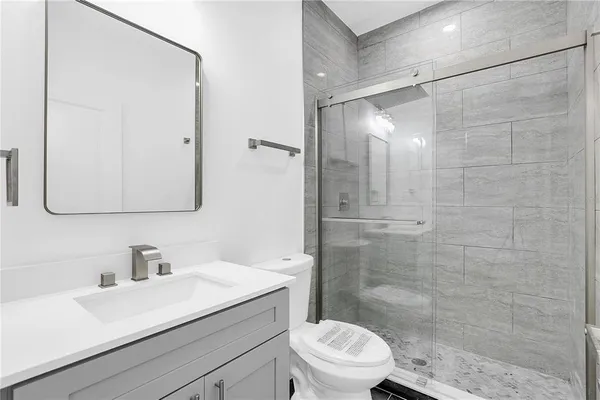 a bathroom with a sink a toilet and shower