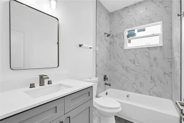 a bathroom with a sink toilet a mirror and shower