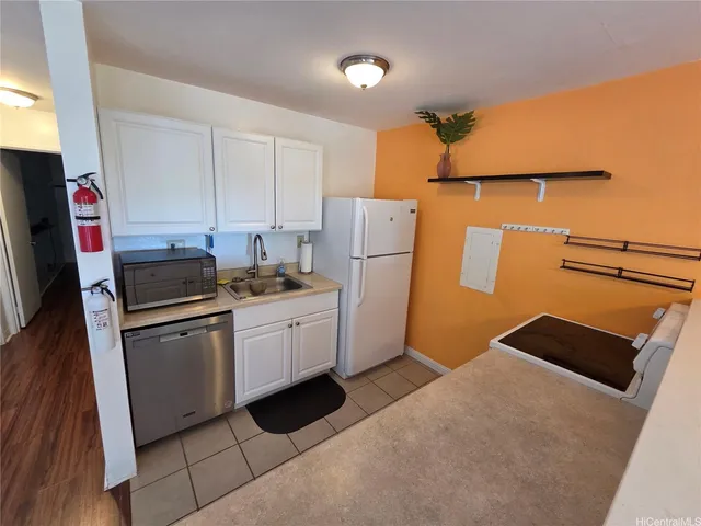 a kitchen with a refrigerator sink and white cabinets