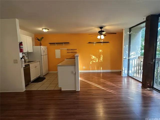 a view of a livingroom with wooden floor and a ceiling fan