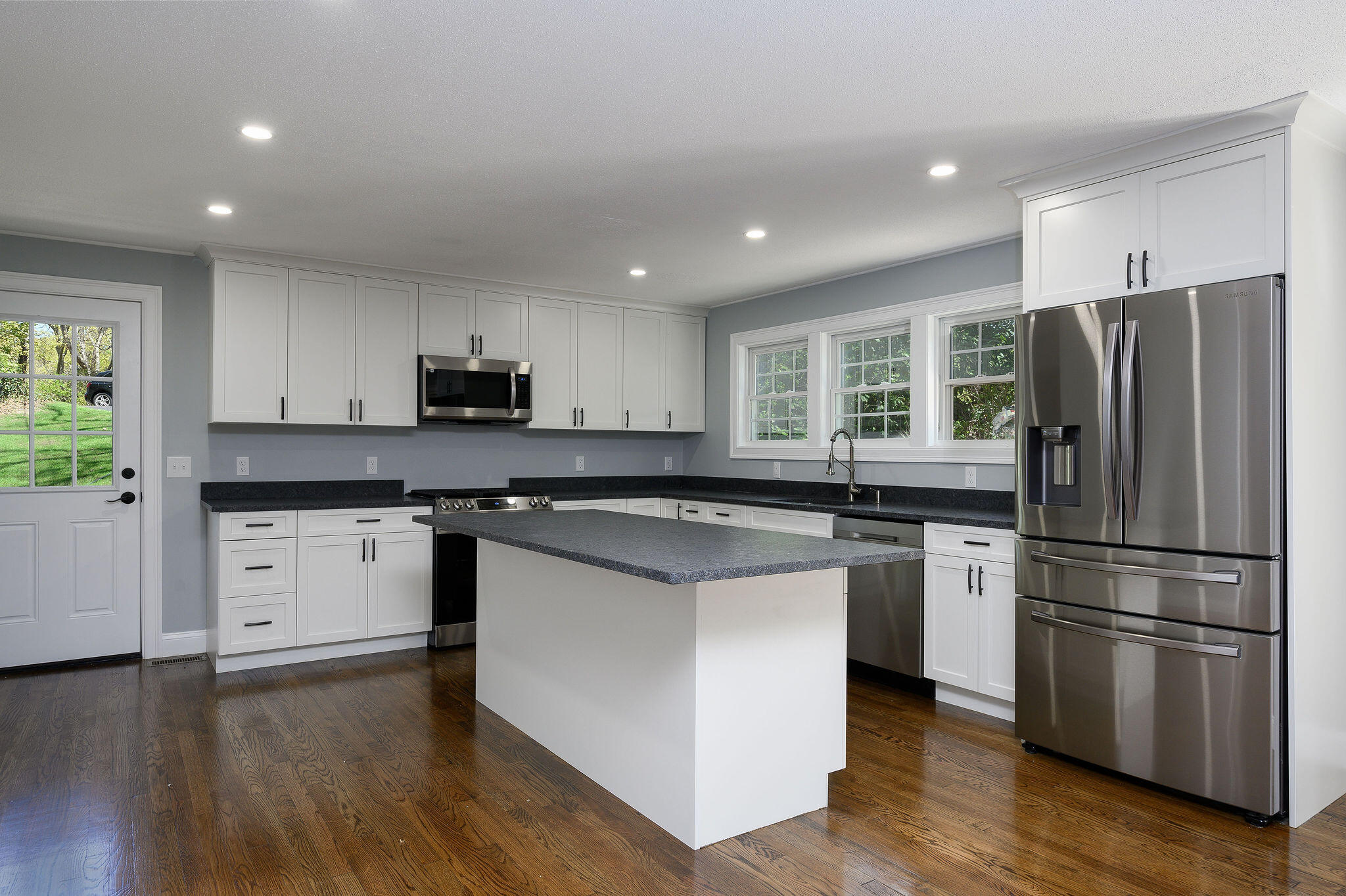 a kitchen with stainless steel appliances granite countertop a refrigerator stove and sink