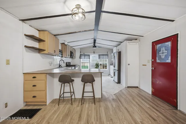 a kitchen with a refrigerator and white cabinets