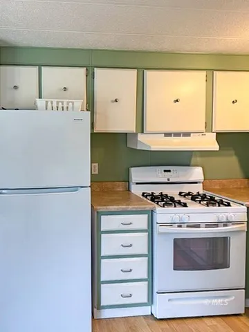 a white stove top oven sitting inside of a kitchen