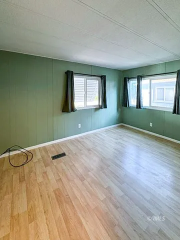 a view of a room with wooden floor and window