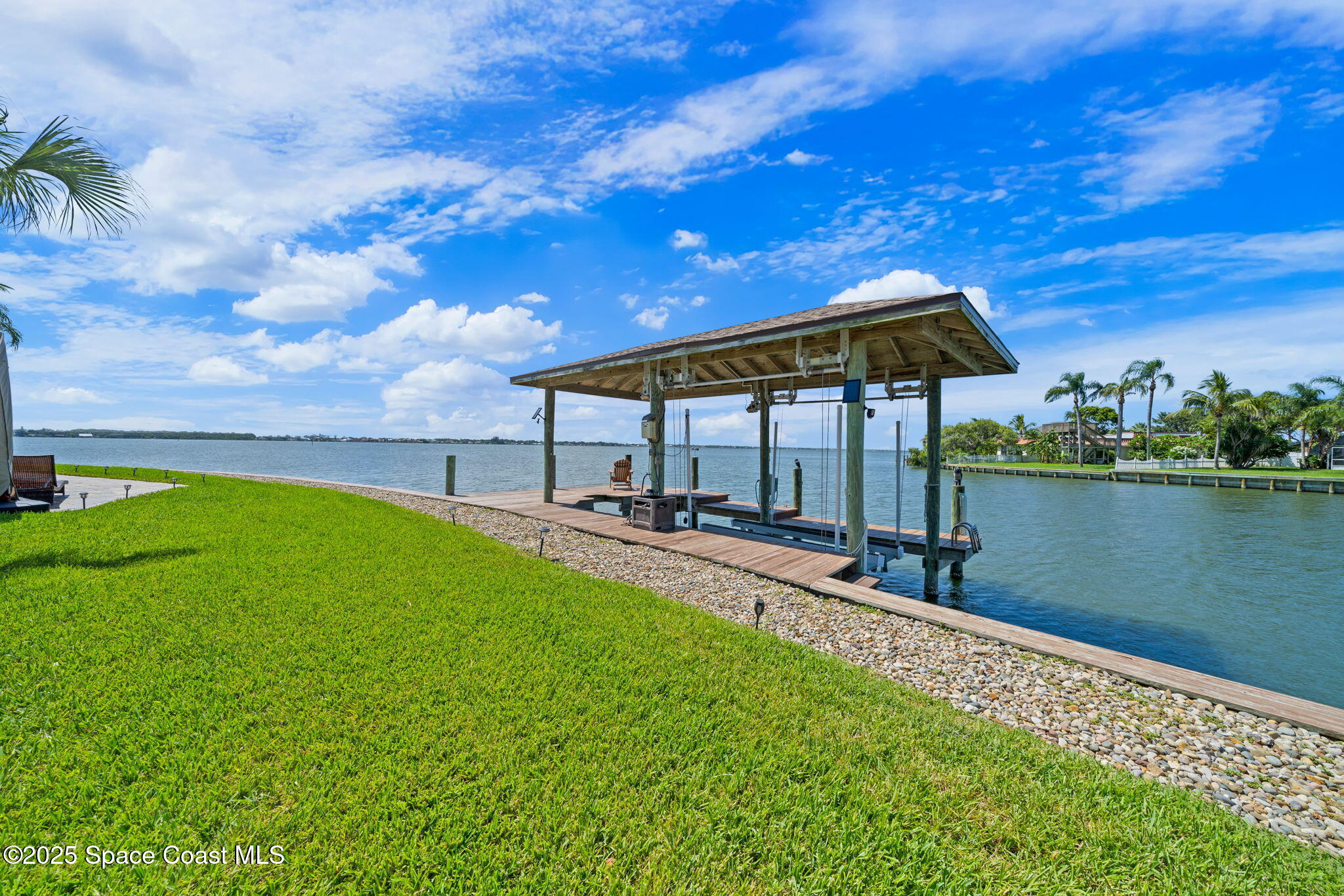 84 Country Club Road Cocoa Beach, FL 32931 - Photo 54 of 69 a view of a swimming pool with a table and chairs under an umbrella
