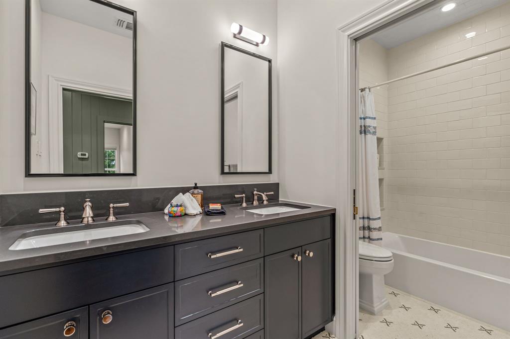 3913 Hamilton Avenue Fort Worth, TX 76107 - Photo 30 of 40 a bathroom with a double vanity sink and mirror with toilet