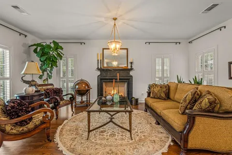 a living room with furniture a dining table and a chandelier
