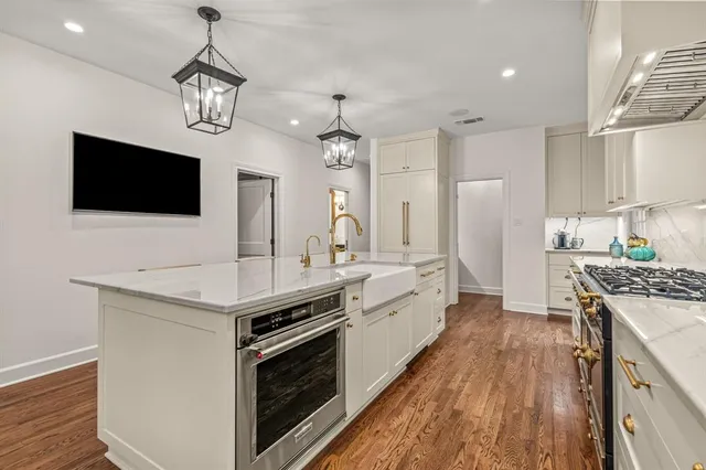 a large kitchen with stainless steel appliances granite countertop a stove and a view of kitchen