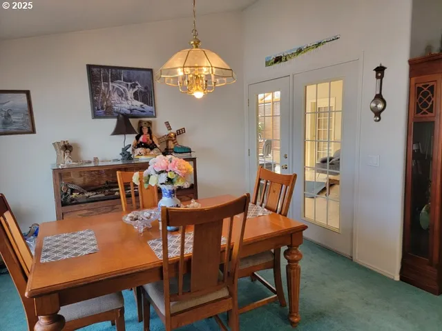 a view of a dining room with furniture a chandelier and wooden floor