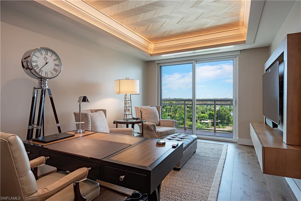 13915 Old Coast Road, Unit 602 Naples, FL 34110 - Photo 15 of 37 a living room with a table chairs and a flat screen tv