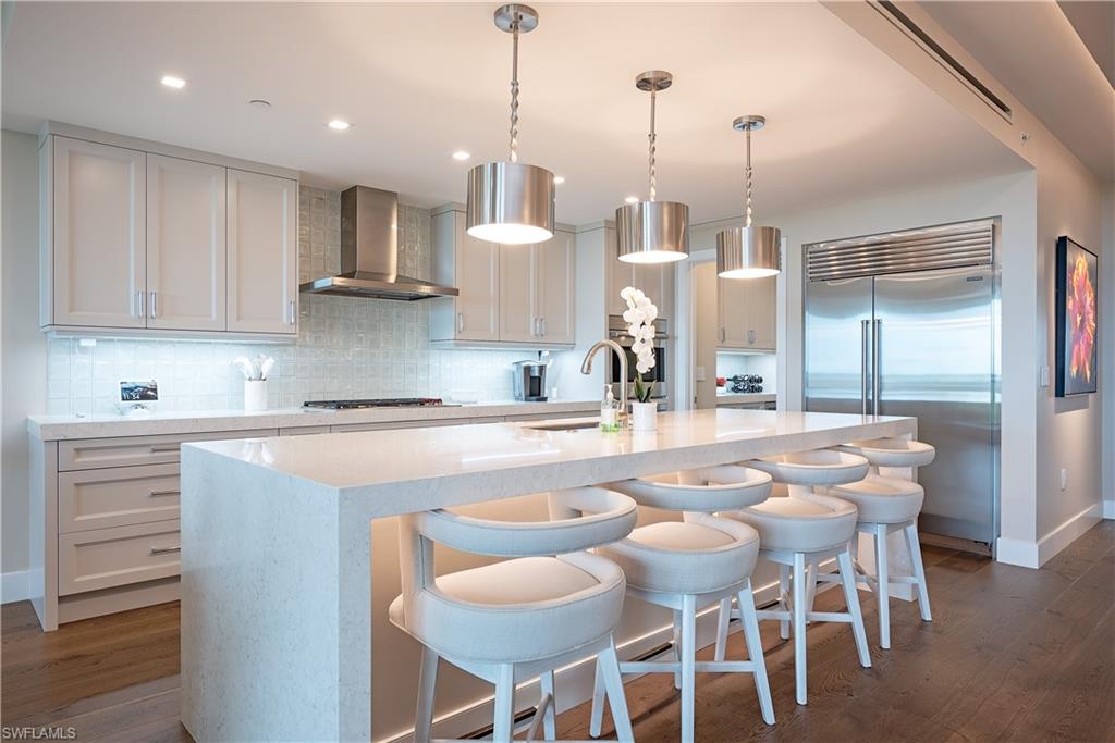 13915 Old Coast Road, Unit 602 Naples, FL 34110 - Photo 9 of 37 a kitchen with stainless steel appliances kitchen island granite countertop a refrigerator and cabinets