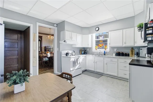 a kitchen with white cabinets and white appliances