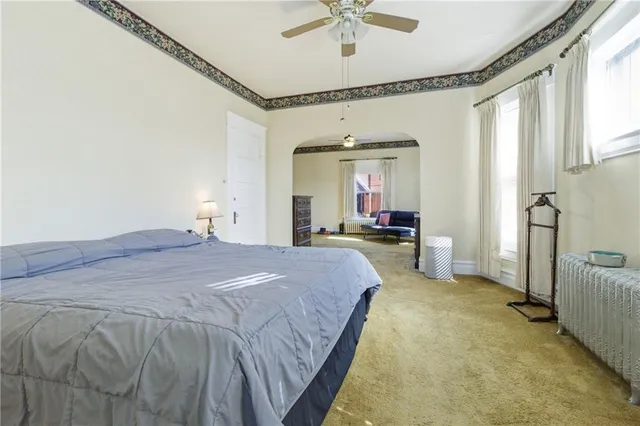 a spacious bedroom with a bed and a chandelier