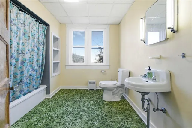 a bathroom with a sink toilet and a window